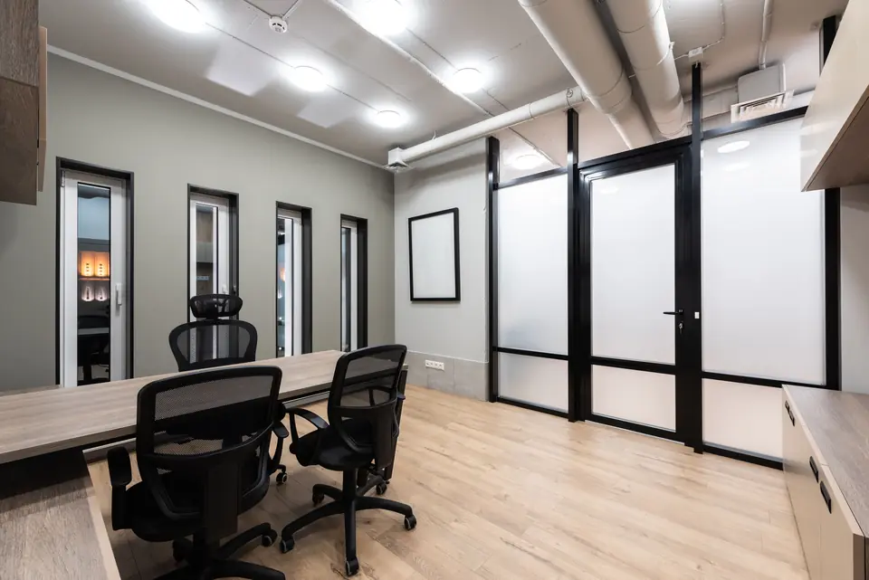 A finished office with a timber table and black chairs
